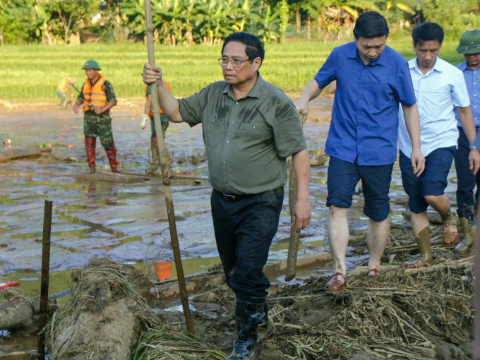 Thủ tướng Phạm Minh Chính chống gậy, lội đến nơi lực lượng chức năng đang tìm kiếm nạn nhân mất tích vì lũ quét ở thôn Làng Nủ, xã Phúc Khánh, huyện Bảo Yên, tỉnh Lào Cai, chiều 12/9. Ảnh: Thanh Hằng